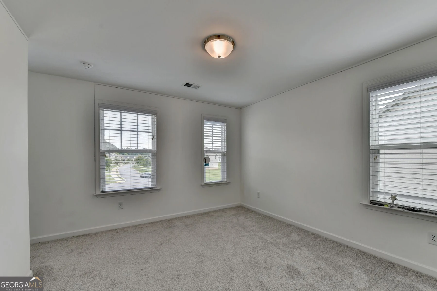 Bedroom with carpet and two windows